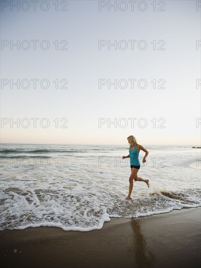 Portrait of woman running on beach.