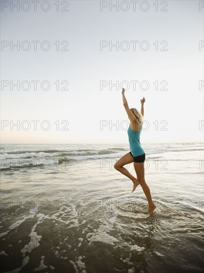 Portrait of woman running on beach.