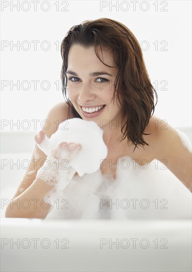 Young woman taking bath. Photo : Momentimages