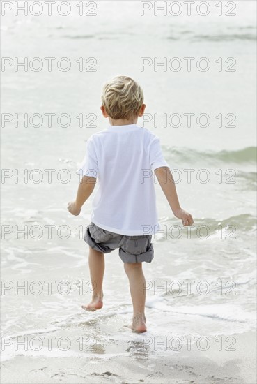 Portrait of boy (4-5) playing on beach. Photo : Momentimages