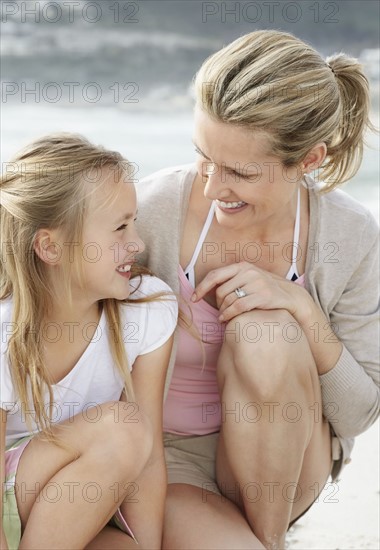 Girl (10-11) playing on beach with mother. Photo : Momentimages