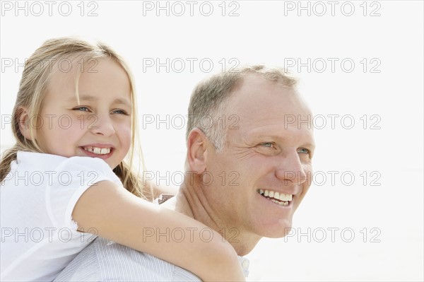 Girl (10-11) playing on beach with father. Photo : Momentimages