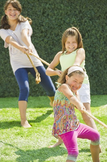 Sisters (2-3, 8-9,12-13) playing tug-of-war. Photo : Daniel Grill