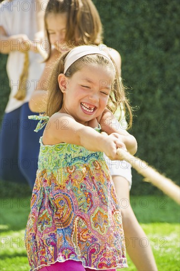 Sisters (2-3, 8-9,12-13) playing tug-of-war. Photo : Daniel Grill