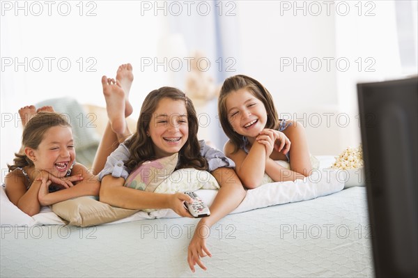 Smiling sisters (2-3, 8-9,12-13) watching TV. Photo : Daniel Grill