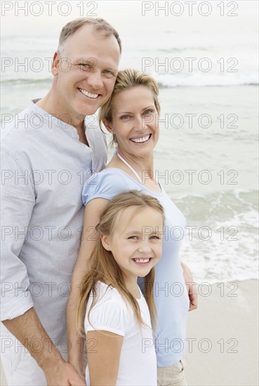 Portrait of smiling parents with daughter (10-11). Photo : Momentimages