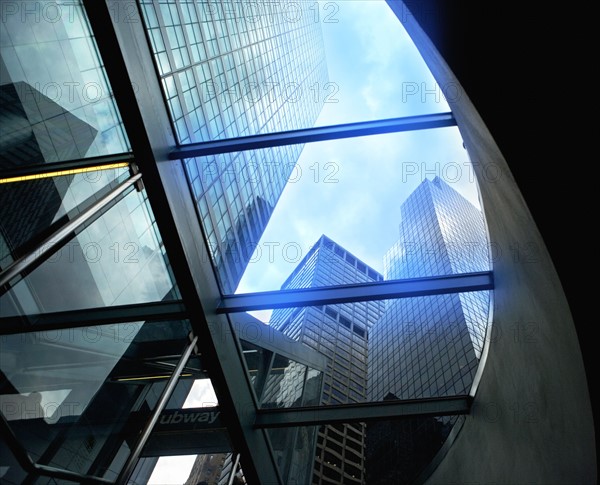 USA, New York State, New York City, Tall skyscrapers seen through glass ceiling of modern office building. Photo : fotog