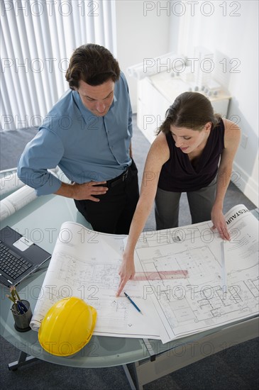 Architects with blueprints in office.