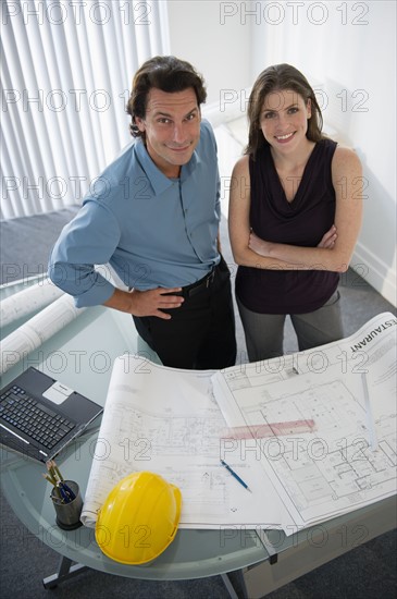 Architects with blueprints in office.