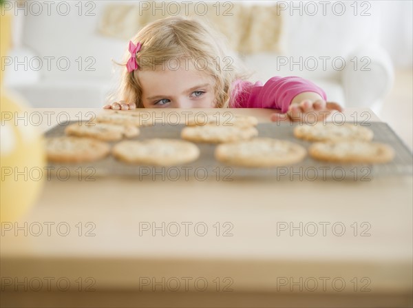 Girl (4-5) reaching for cookies. Photo : Jamie Grill