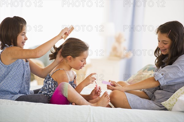 Sisters making hairstyle and painting toenails (2-3, 8-9, 12-13). Photo : Daniel Grill