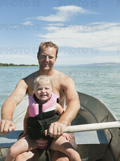 Father and daughter (2-3) on boat.