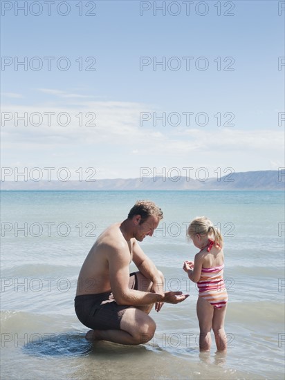 Father and daughter (2-3) at lake.