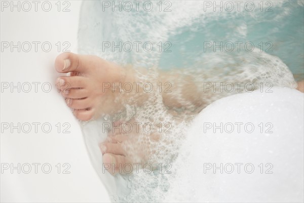 Young woman taking bath. Photo : Momentimages
