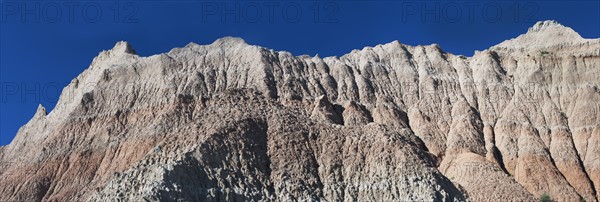 USA, South Dakota, Mountain against blue sky in Badlands National Park.