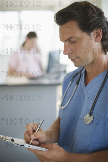 Doctor writing documentation in hospital.