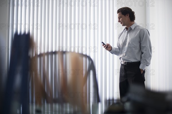 Man in office using mobile phone.