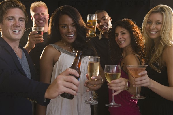 Portrait of friends celebrating with champagne at nightclub. Photo : Jamie Grill