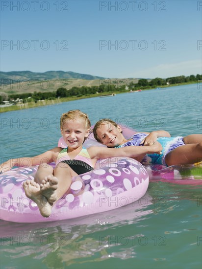 Girls (6-7,8-9) floating on inflatable toys.