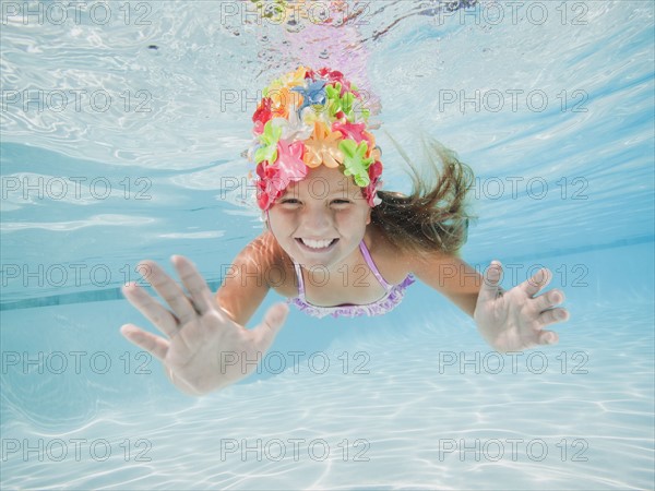 Girl (8-9) swimming underwater.