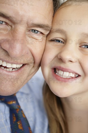 Portrait of smiling grandfather and granddaughter (10-11). Photo : Momentimages