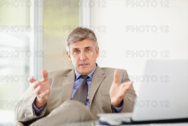 Portrait of cheerful businessman with laptop. Photo : Momentimages