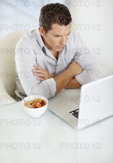 Portrait of enthusiastic man working on laptop. Photo : Momentimages