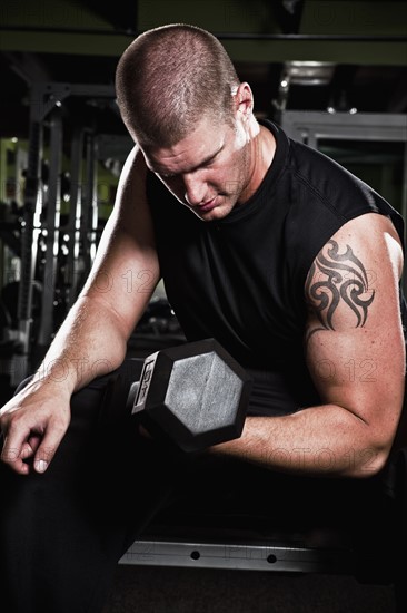 Mid adult man working out in gym. Photo : Take A Pix Media