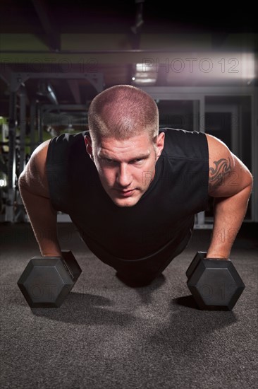 Mid adult man working out in gym. Photo : Take A Pix Media