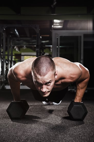 Mid adult man working out in gym. Photo : Take A Pix Media