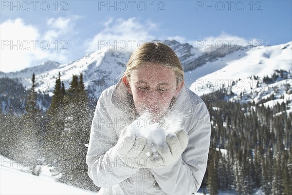 Girl (10-11) blowing snow in mountains. Photo : Johannes Kroemer