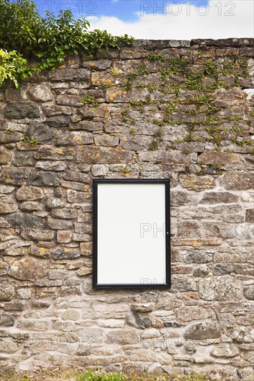Blank sign on stone wall . Photo : Jon Boyes