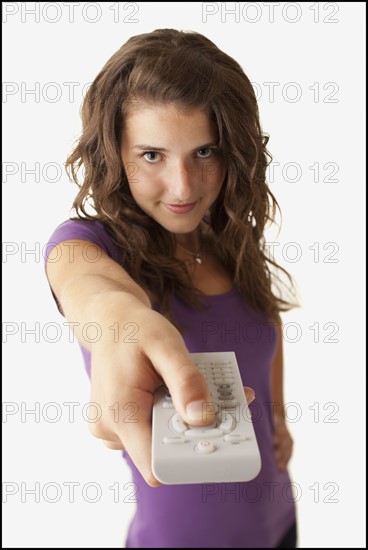 Young woman holding remote control. Photo : Mike Kemp