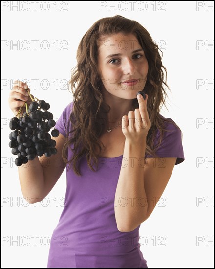 Young woman eating grapes. Photo : Mike Kemp