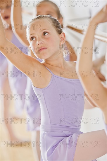 Female ballet dancer (6-8) in dance studio. Photo : Mike Kemp