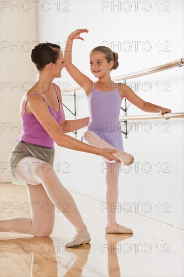 Female instructor training ballet dancer (6-7) in dance studio. Photo : Mike Kemp