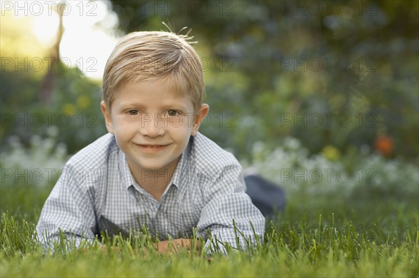 Portrait of boy (6-7) lying on grass. Photo : FBP