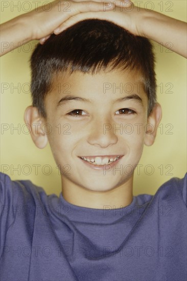 Cute young boy with his hands on his head. Photo : Fisher Litwin