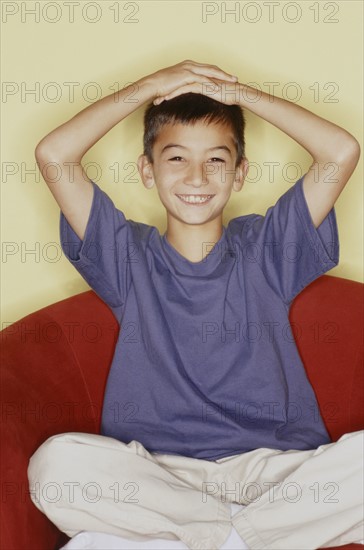 Cute young boy with his hands on his head. Photo : Fisher Litwin