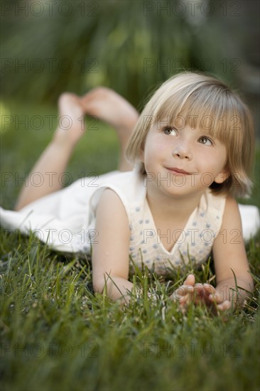 Girl (2-3) lying on grass. Photo : FBP