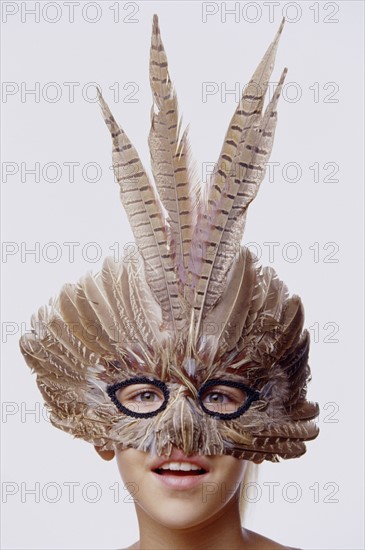 Child wearing a feather mask. Photo : Fisher Litwin