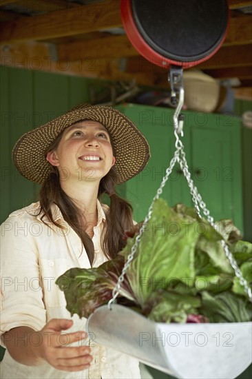 Young woman weighing cabbages. Photo : Shawn O'Connor