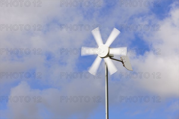 Old wind turbine against cloudy sky. Photo : Jon Boyes