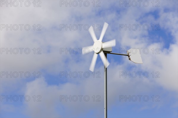 Old wind turbine against cloudy sky. Photo : Jon Boyes
