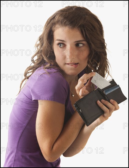 Young woman removing banknote from wallet. Photo : Mike Kemp