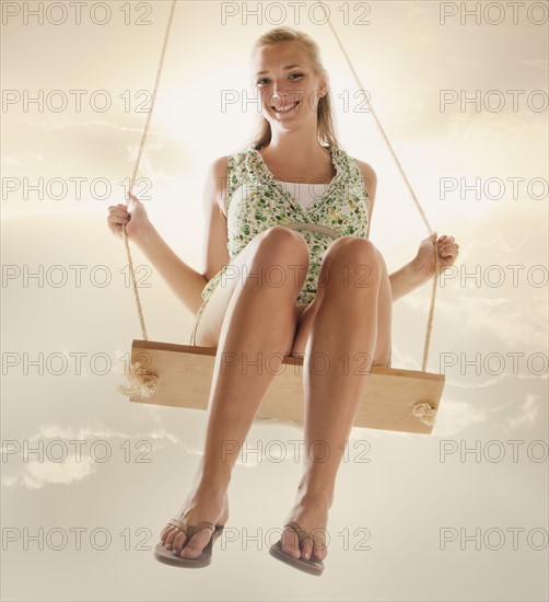 Portrait of young girl (16-17) on swing. Photo : Mike Kemp