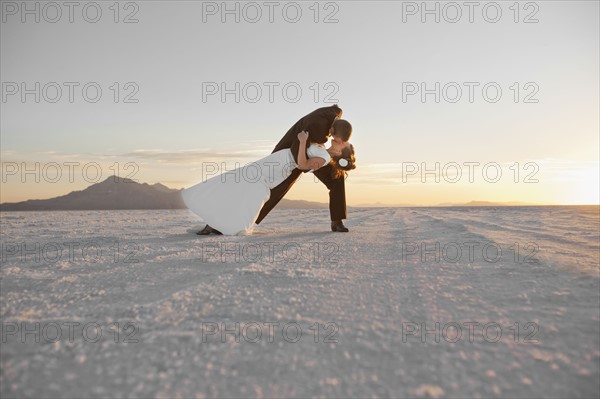 Groom kissing bride in desert. Photo : FBP