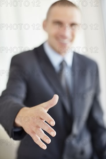 Businessman offering hand for handshake. Photo : Momentimages