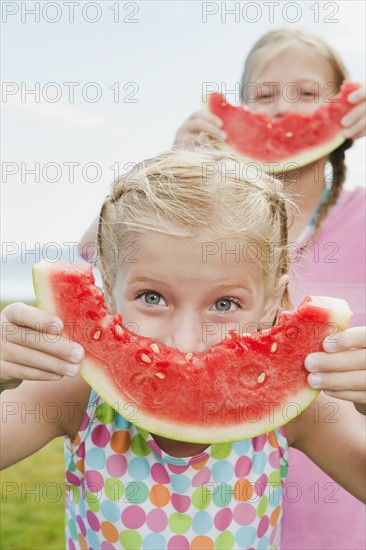 Girls (6-7,8-9) eating watermelon.