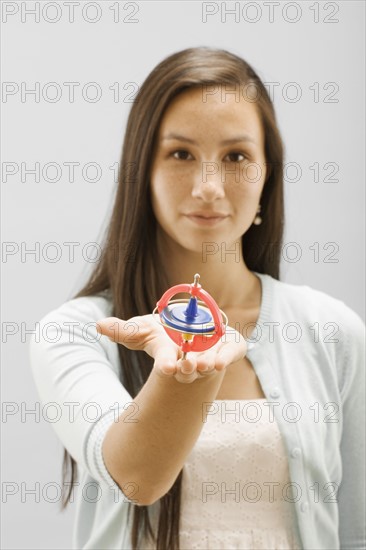 Studio portrait of young woman holding gyroscope. Photo : FBP